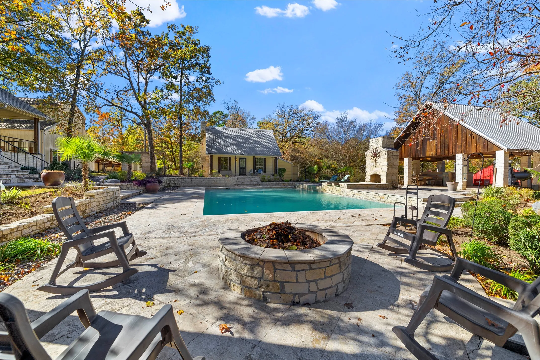 Outdoor pool featuring a patio, a fire pit, an outdoor structure, and a storage structure