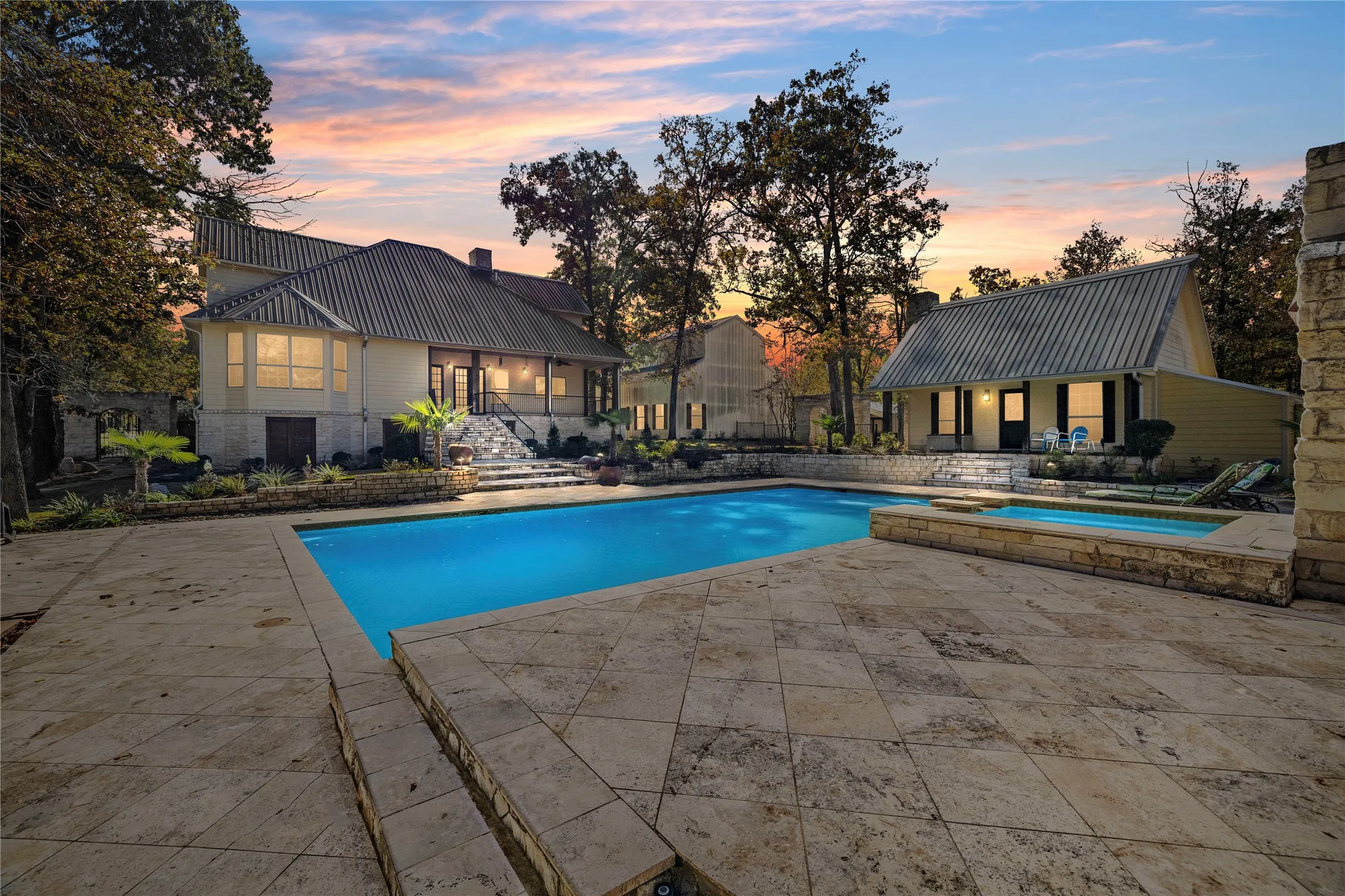 View of swimming pool featuring a patio area, a pool with connected hot tub, and an outbuilding