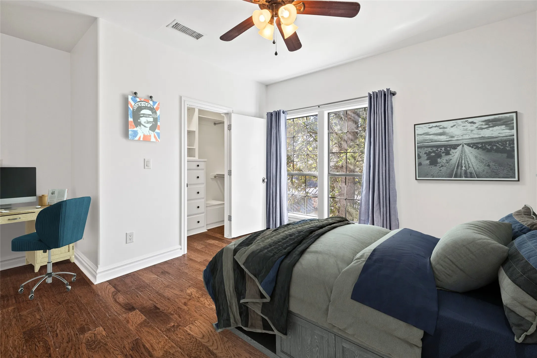 Bedroom featuring a spacious closet, wood finished floors, a ceiling fan, and an office area