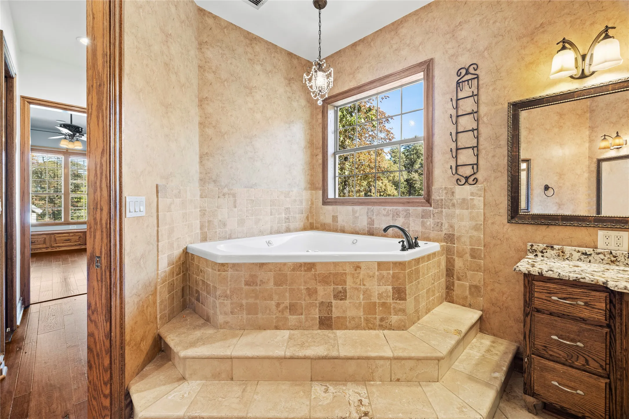 Full bath featuring a bath, tile walls, and vanity
