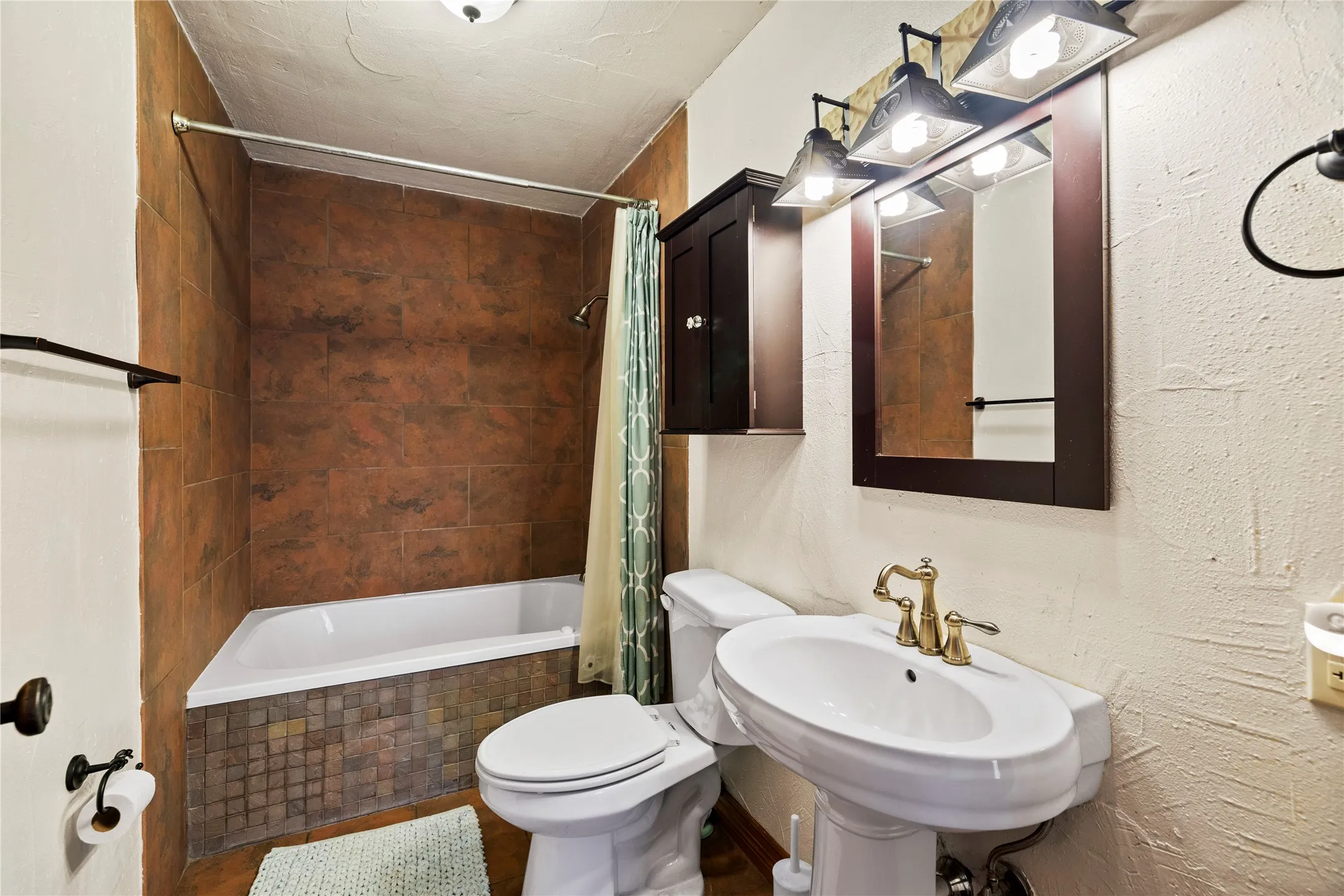 Full bath with tiled shower / bath and a textured wall