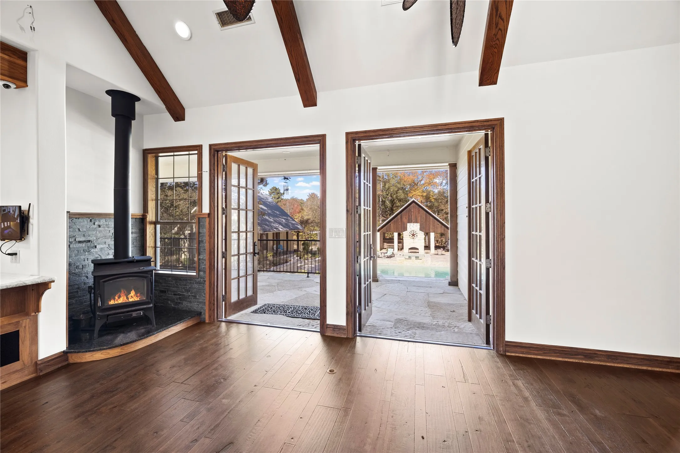 Unfurnished living room featuring a wood stove and dark wood-style flooring