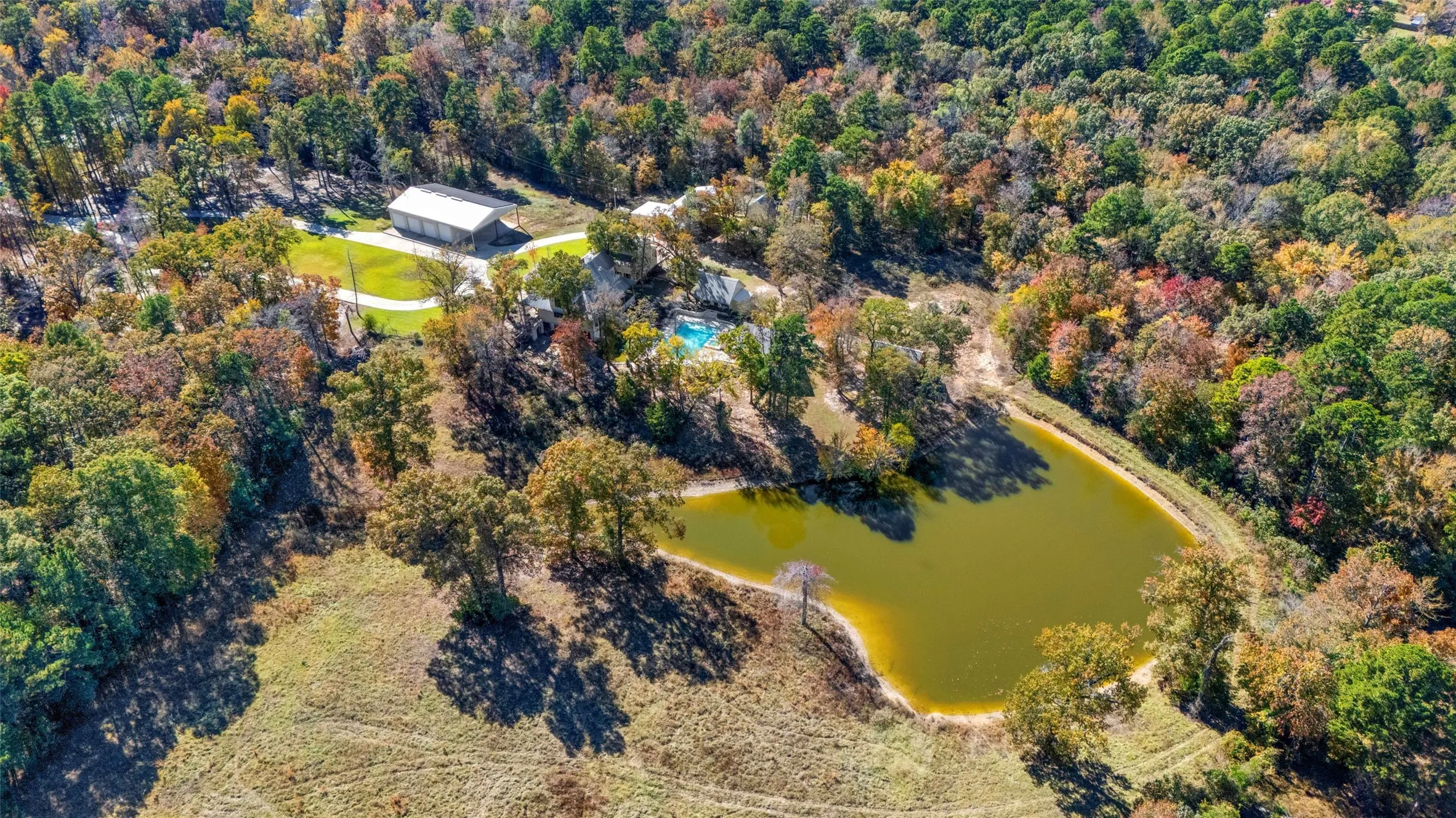 Aerial view of property's location with a large body of water and a forest