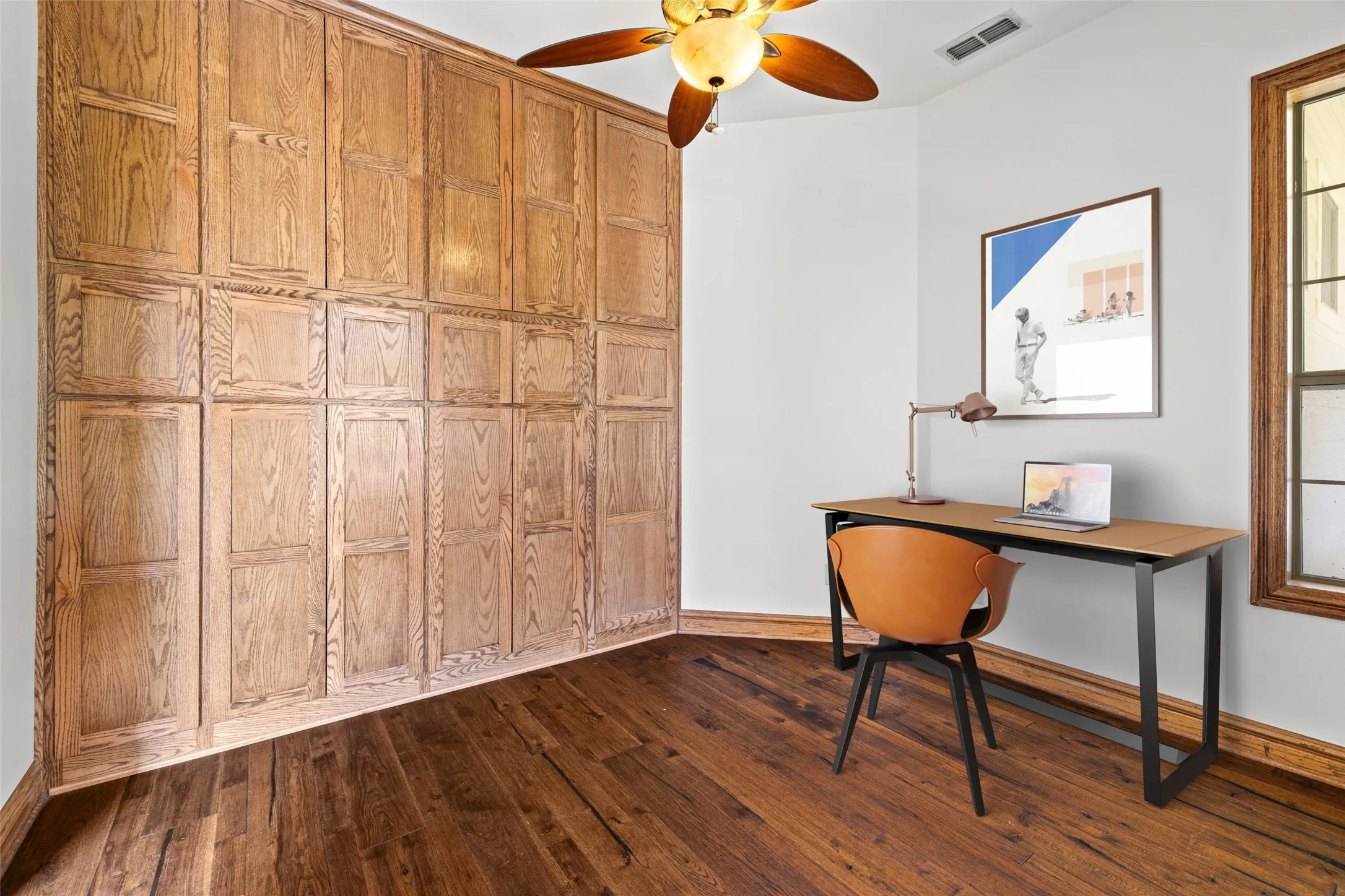 Office area with dark wood-type flooring and a ceiling fan