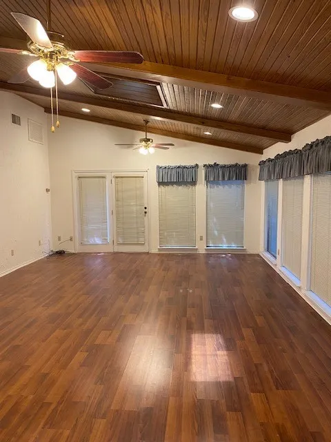 Unfurnished room with visible vents, wooden ceiling, ceiling fans, wood finished floors, and vaulted ceiling with beams
