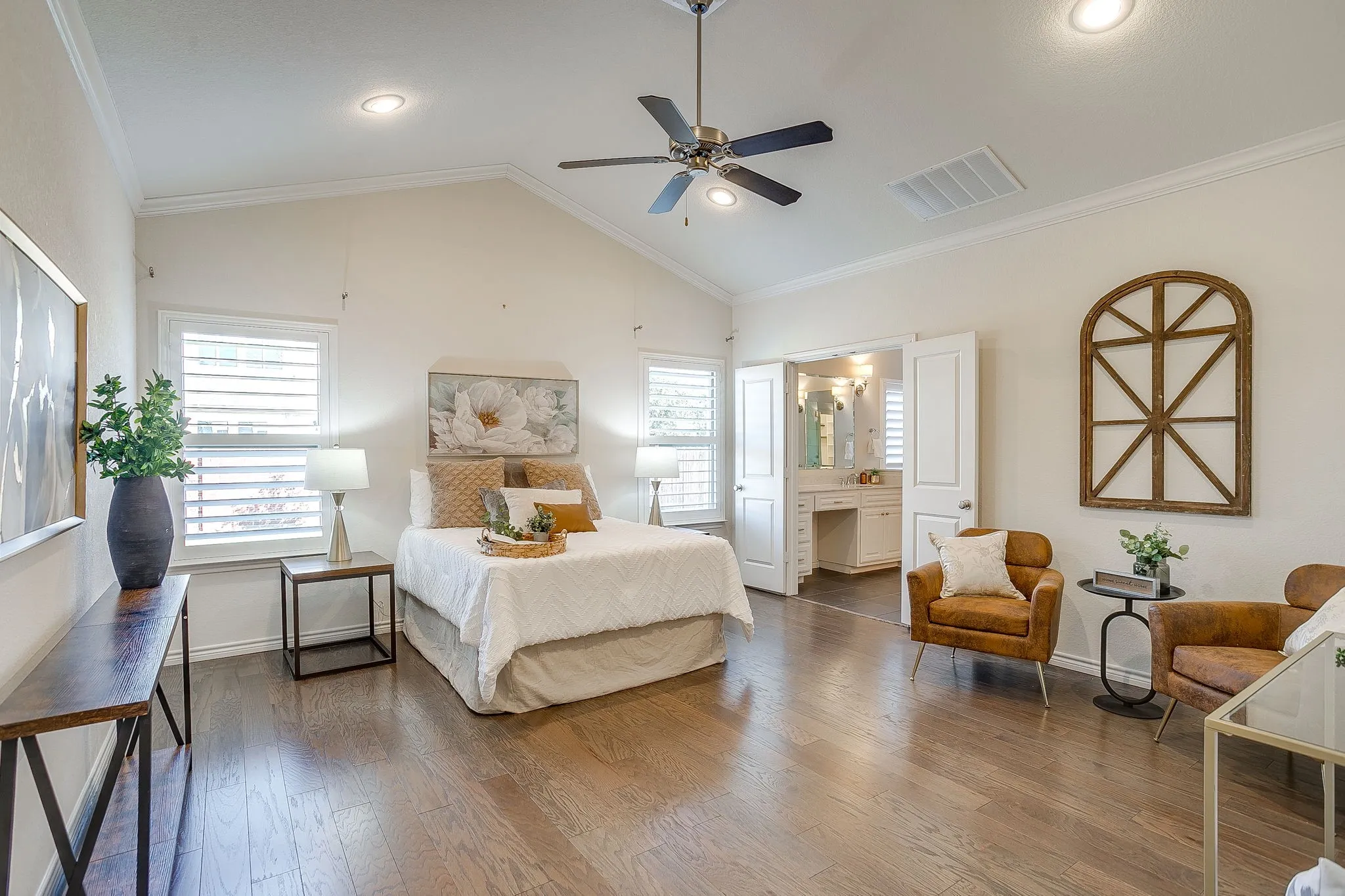 Bedroom with crown molding, lofted ceiling, wood finished floors, multiple windows, and a ceiling fan