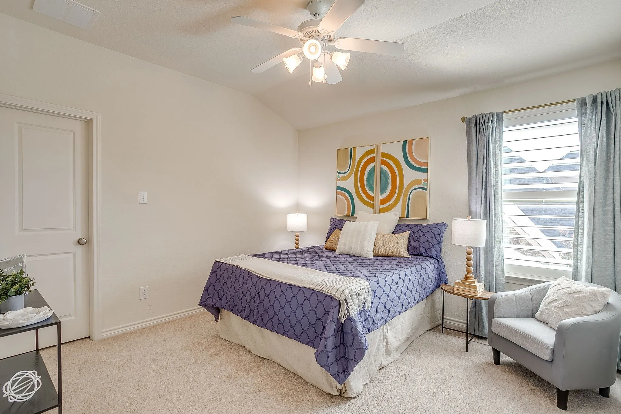 Carpeted bedroom featuring vaulted ceiling and a ceiling fan