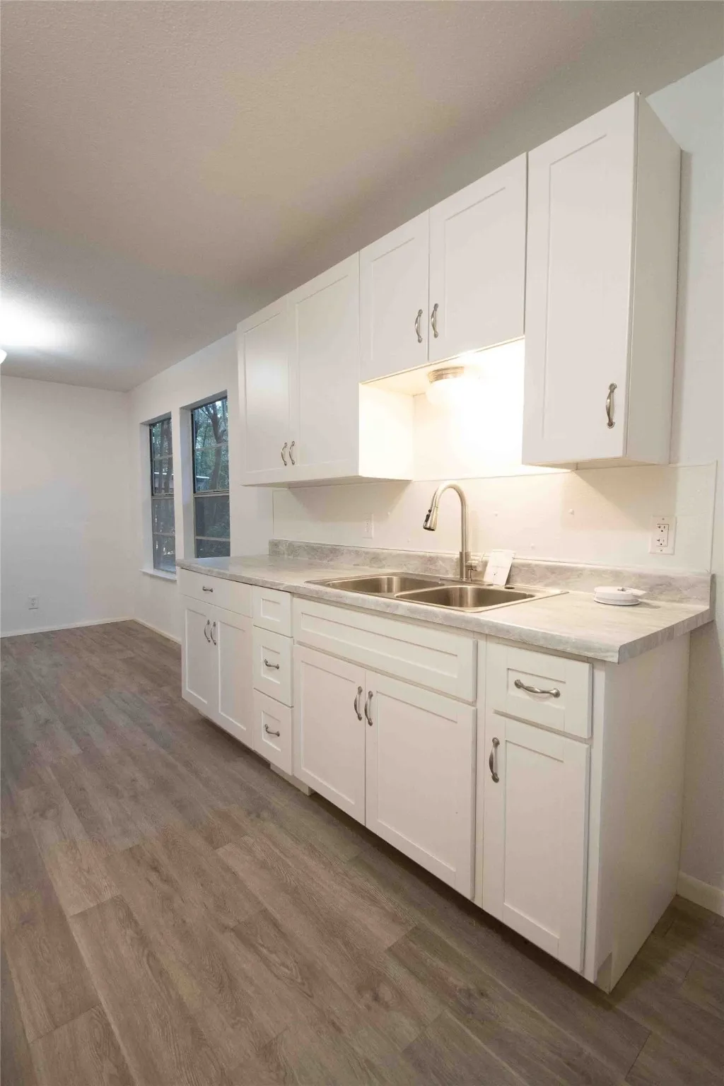 Kitchen featuring white cabinetry, light countertops, and dark wood finished floors