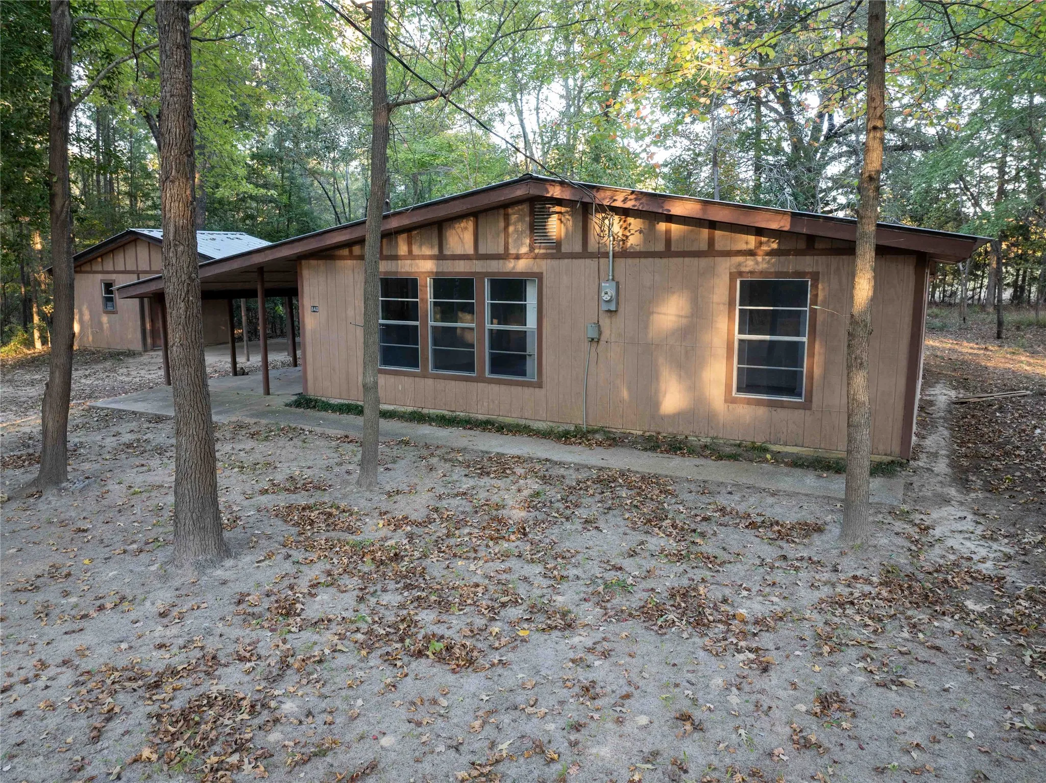 View of the side of home facing the road with carport and storage in background