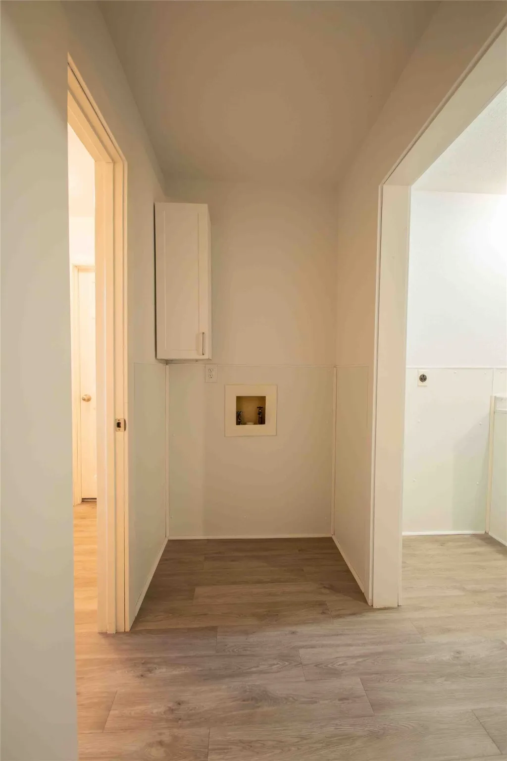 Laundry room featuring light wood-style flooring, hookup for a washing machine, and cabinet space