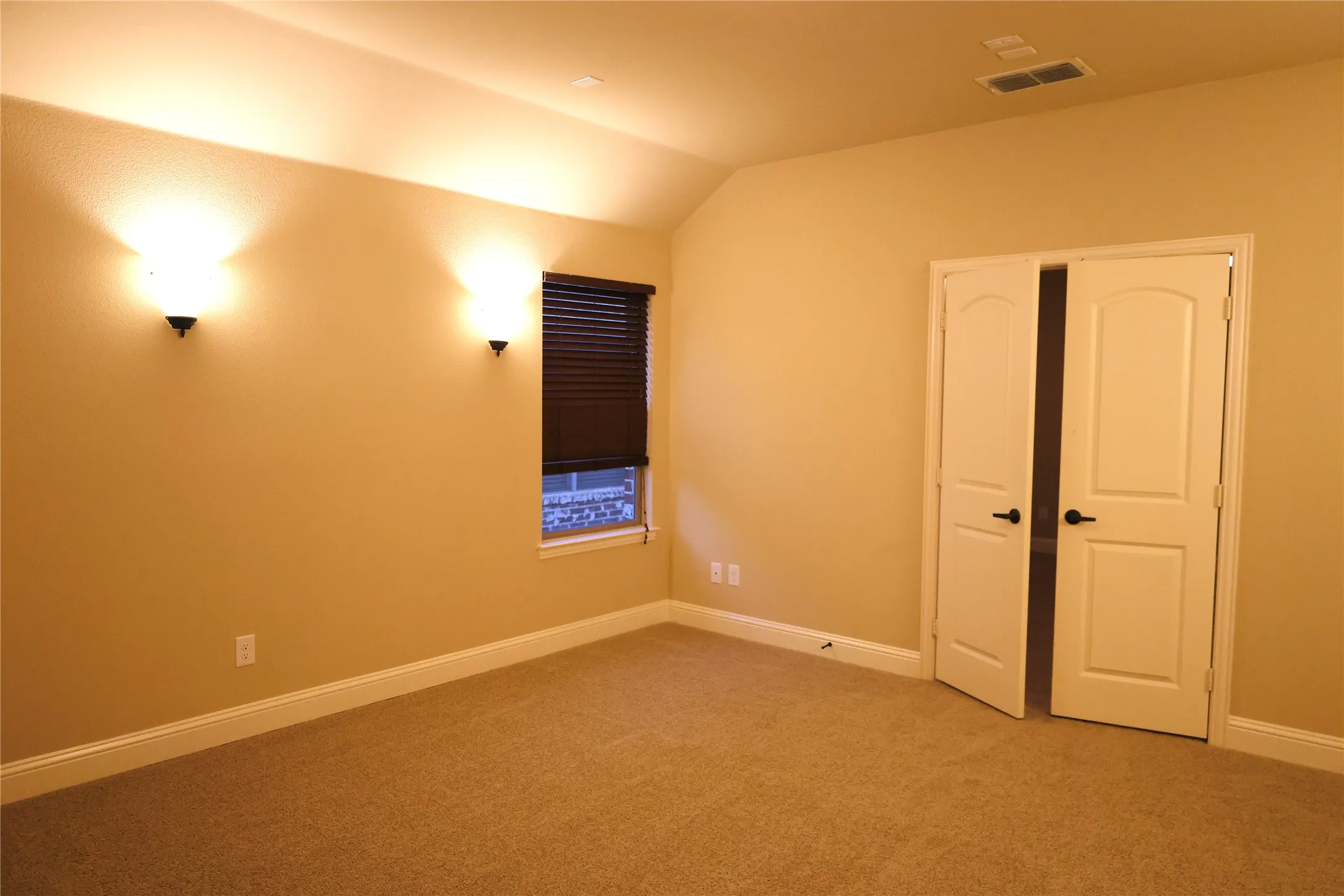 bedroom featuring light carpet and lofted ceiling