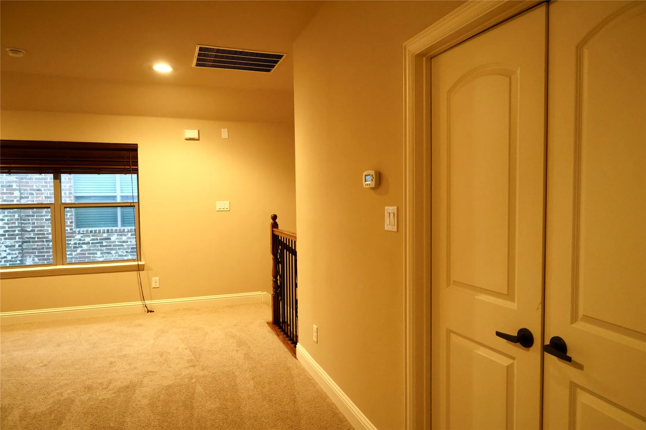 Corridor with carpet floors, an upstairs landing, and recessed lighting