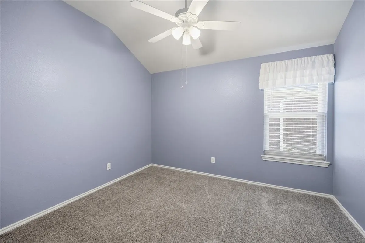 Unfurnished room with carpet floors, a ceiling fan, and lofted ceiling