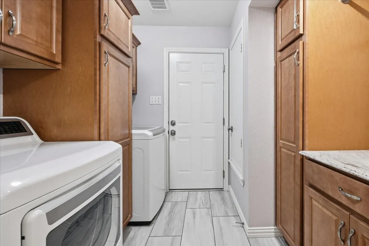 Washroom with cabinet space and washer and clothes dryer