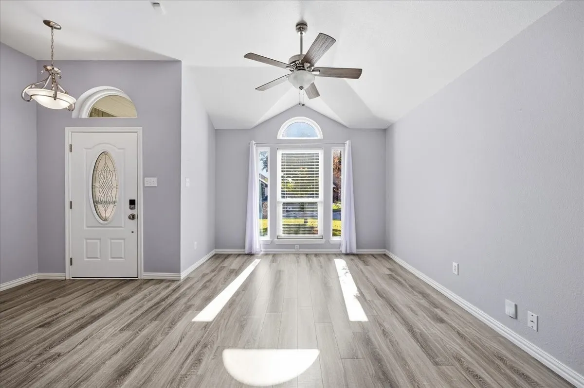 Entrance foyer featuring vaulted ceiling, light wood-type flooring, and ceiling fan