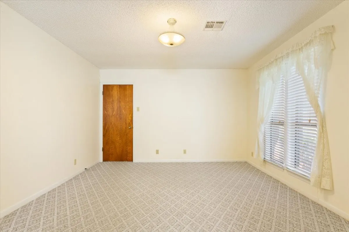Carpeted empty room with a textured ceiling