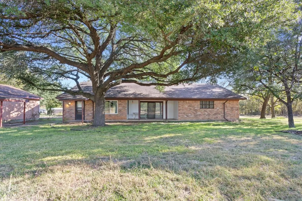 View of front facade featuring a front yard and brick siding