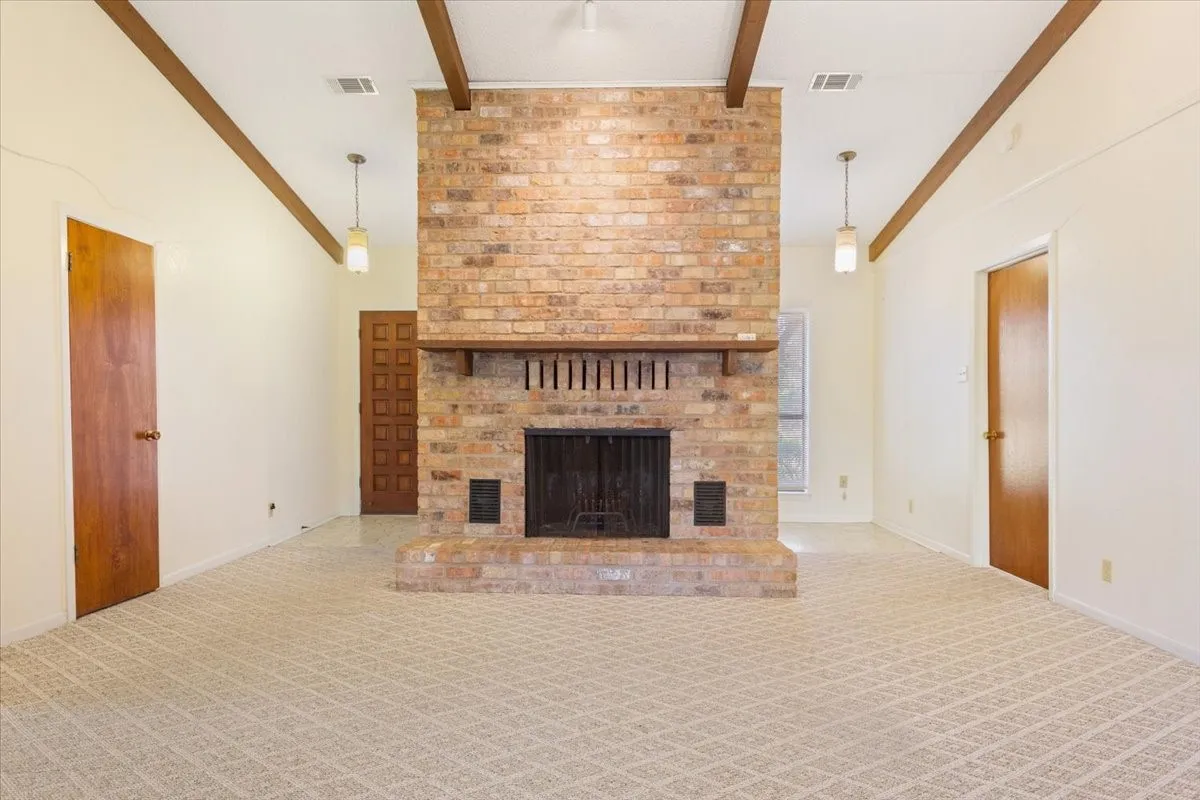 Unfurnished living room with carpet and a fireplace