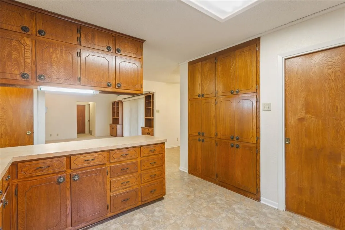 Kitchen featuring brown cabinetry and light countertops