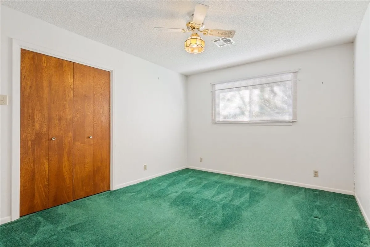 Unfurnished bedroom featuring carpet, a textured ceiling, and a closet