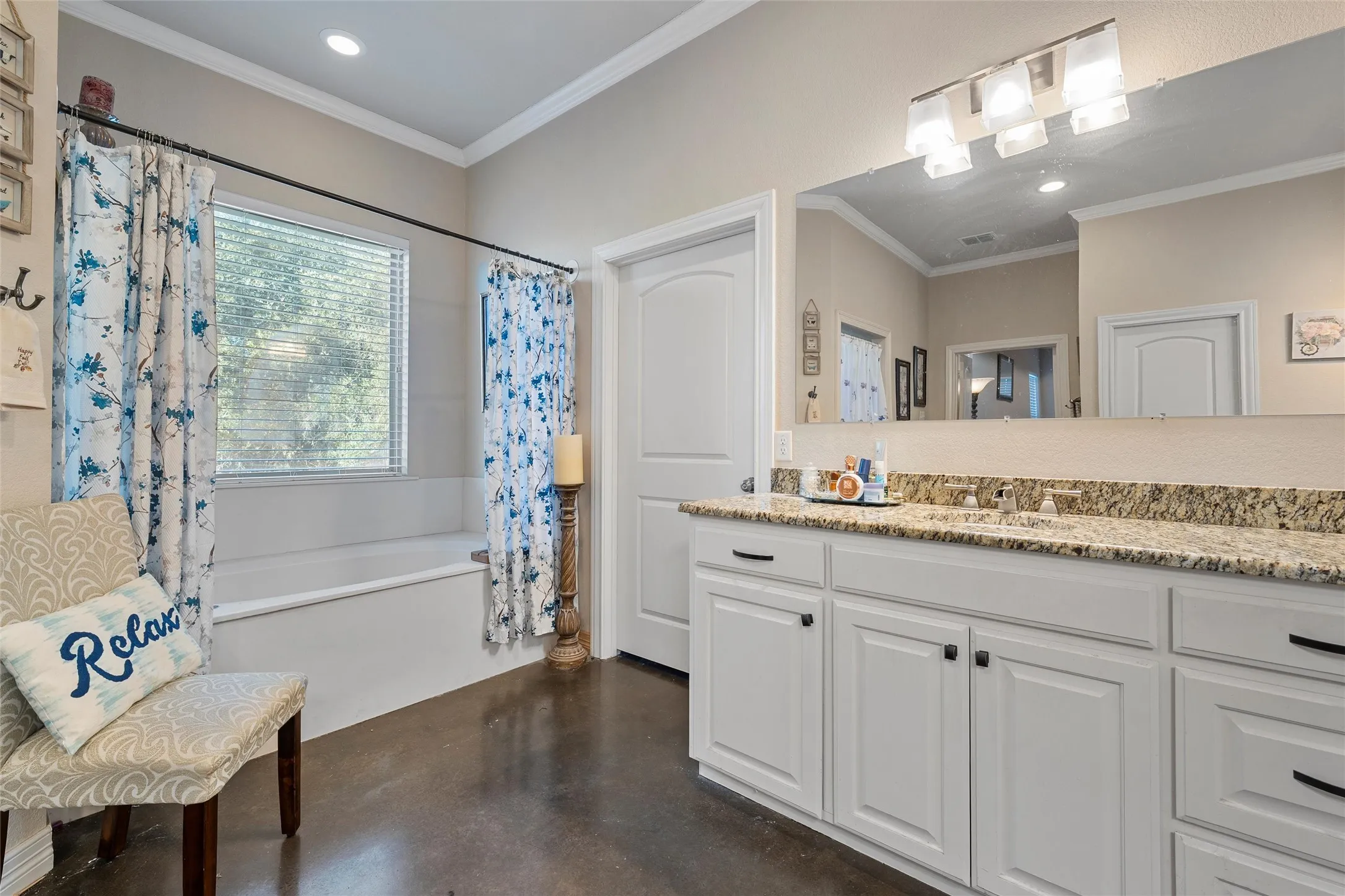 Primary bathroom featuring concrete flooring, vanity, shower / bath combo with shower curtain, crown molding, and recessed lighting