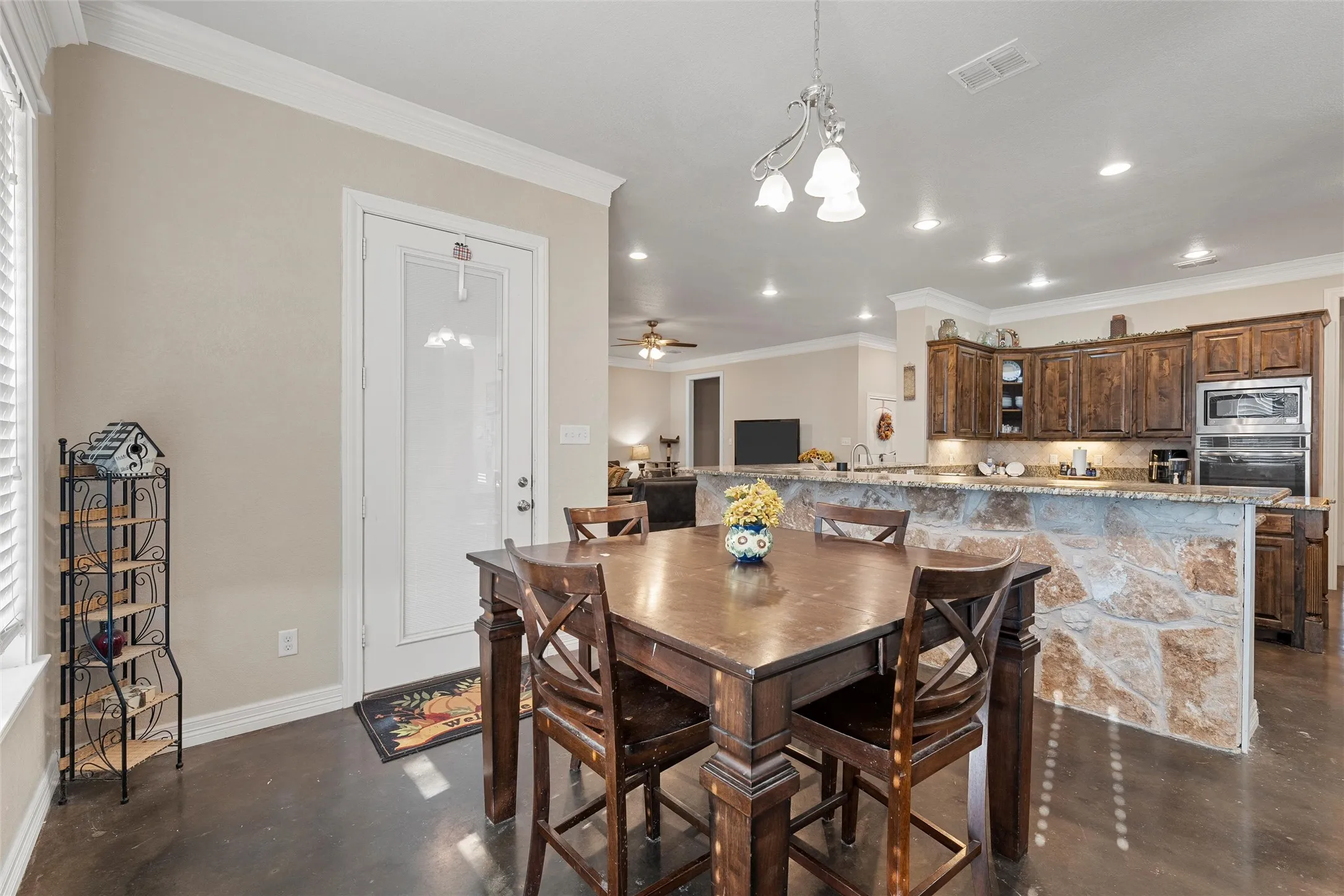 Dining room featuring concrete floors, ornamental molding, recessed lighting, and a ceiling fan