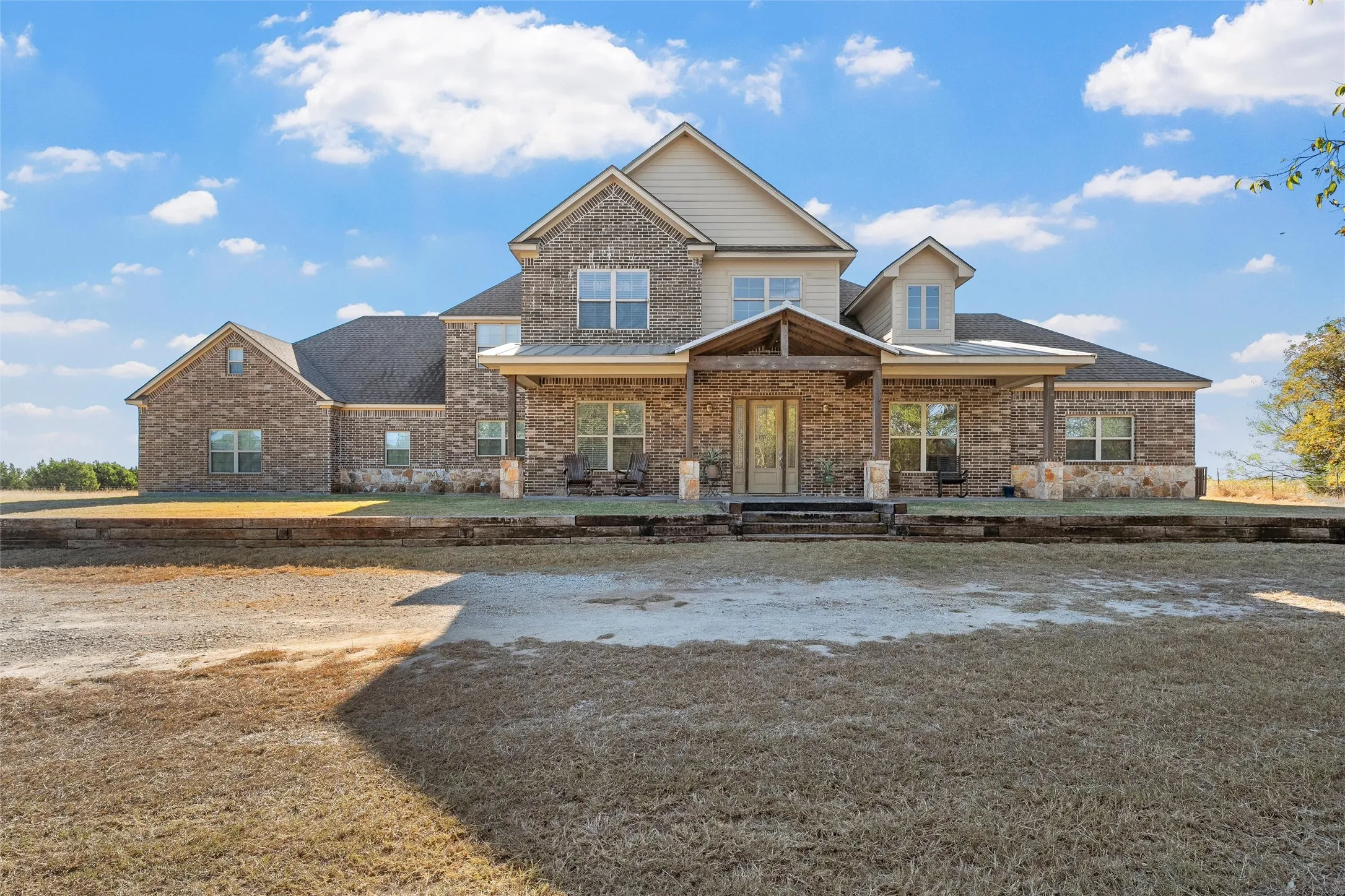 Craftsman house with a porch, brick siding, roof with shingles, and a front lawn
