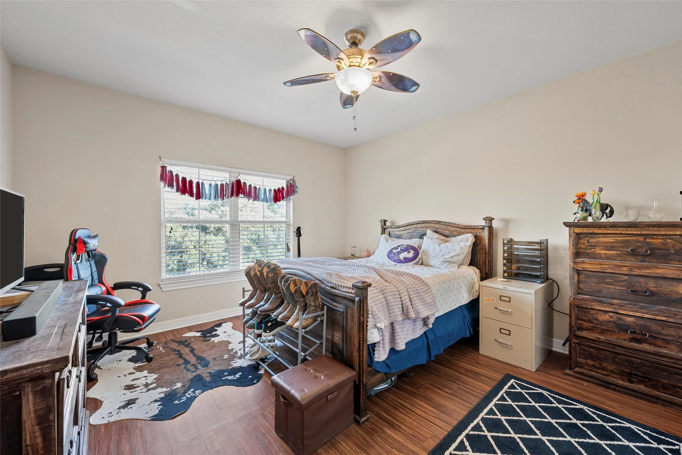 Bedroom #2 with wood finished floors, ceiling fan, and a desk