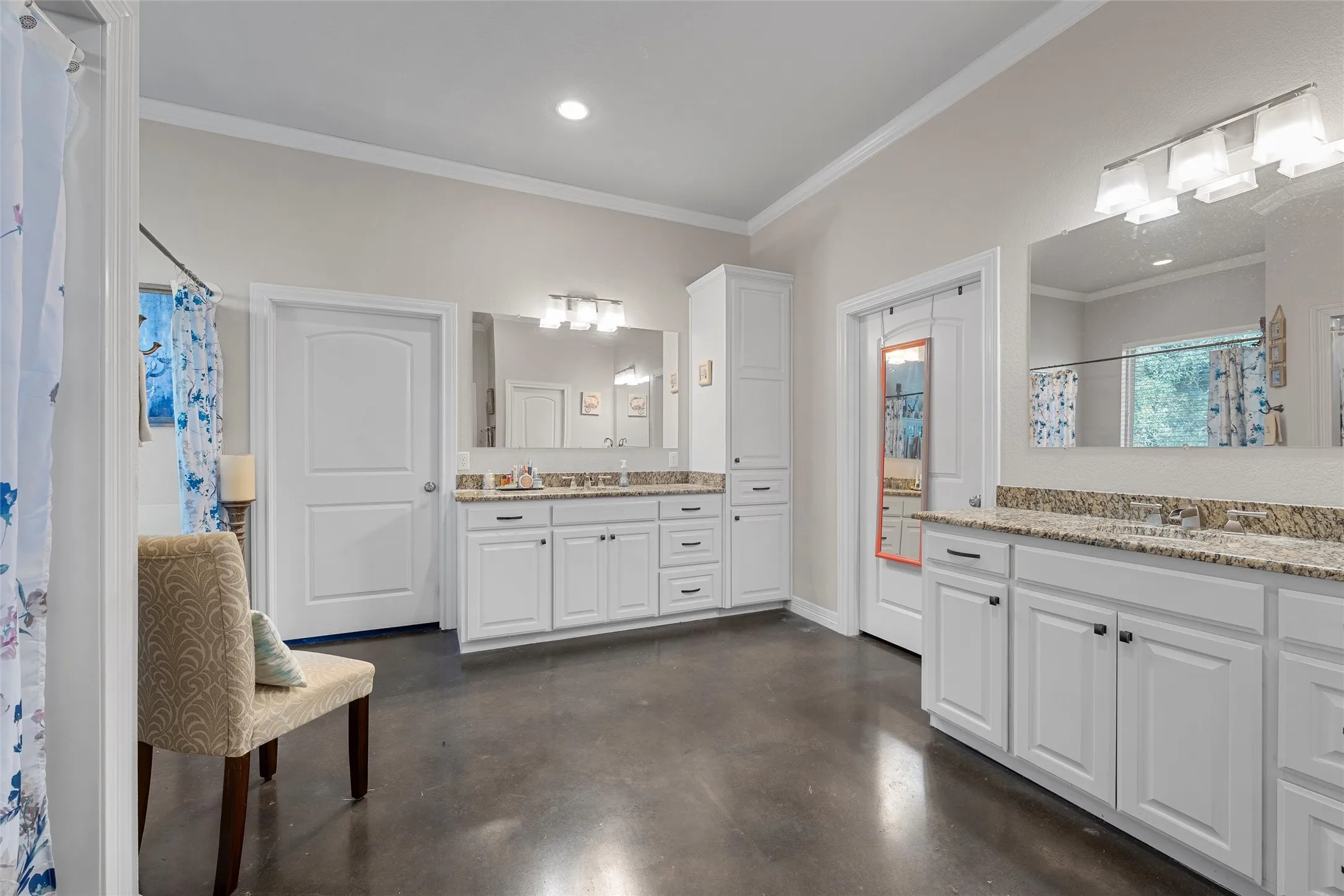 Primary Bathroom featuring ornamental molding, concrete flooring, two vanities, a shower with curtain, and recessed lighting