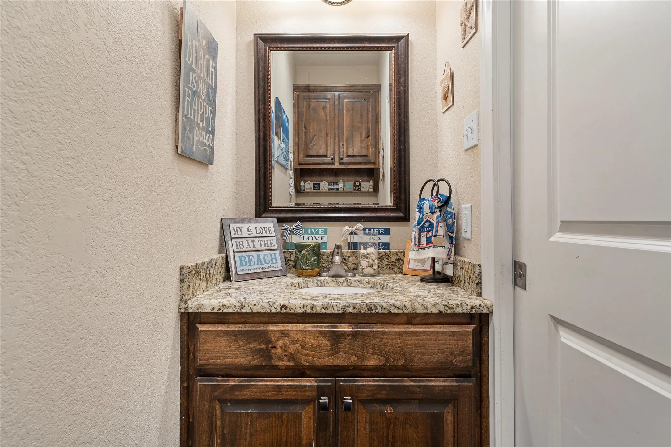 Bathroom with a textured wall and vanity