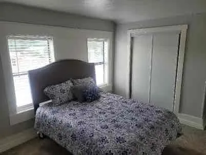 Carpeted bedroom featuring a closet and baseboards