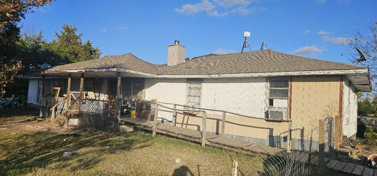 Back of house with a wooden deck, a chimney, and a shingled roof