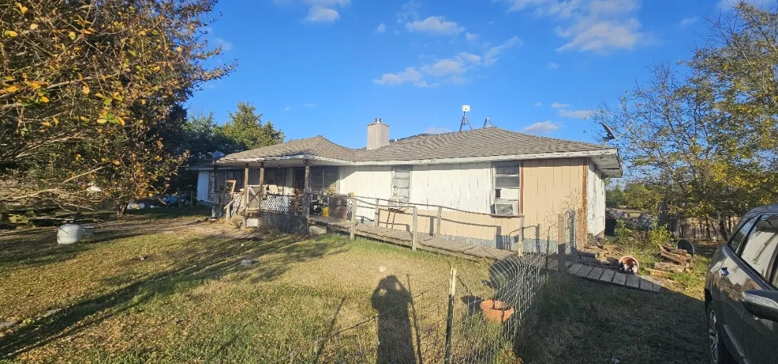Back of house featuring a yard, a chimney, and a deck