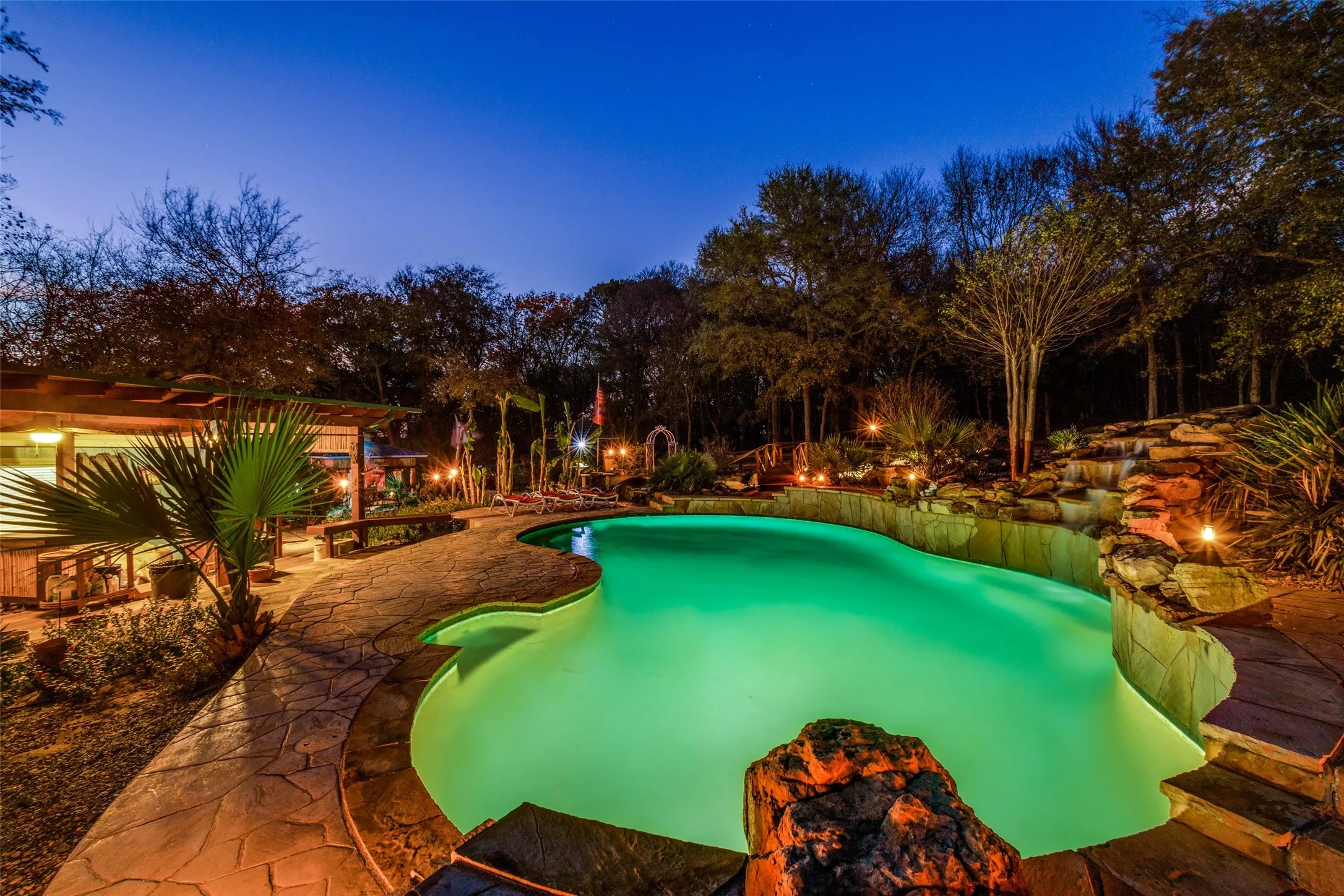 A Resort Style Paradise at Dusk, Where the Pool Glows Against the Backdrop of Towering Trees and a Peaceful Texas Sky. This is the Moment Each Day Feels Like a Retreat.