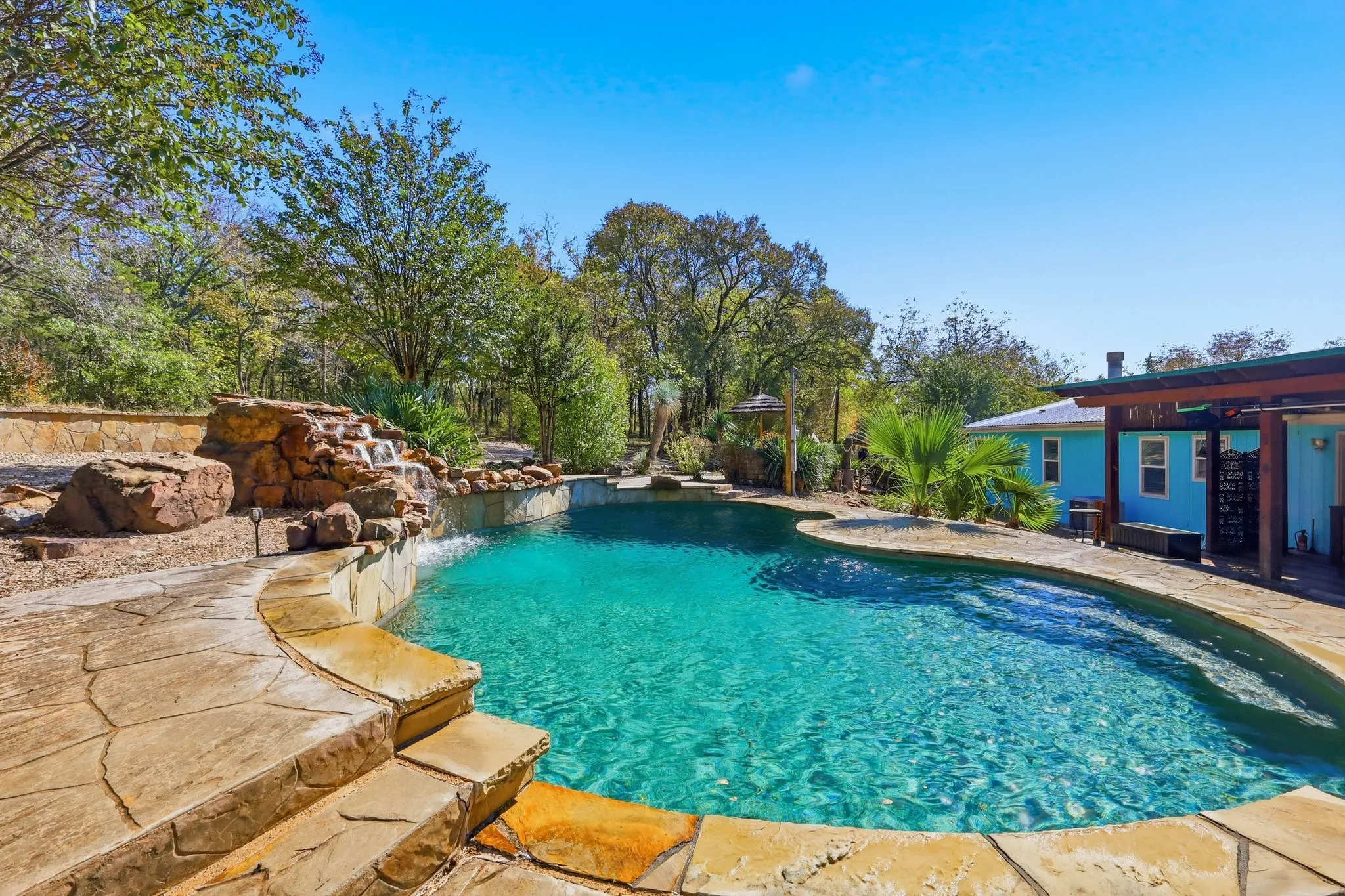 33,000 Gallon, 9 Foot Deep, Diving Swimming Pool with Waterfall, Tanning Ledges, and Rock Diving Board. Imagine the Fun with Family and Friends.