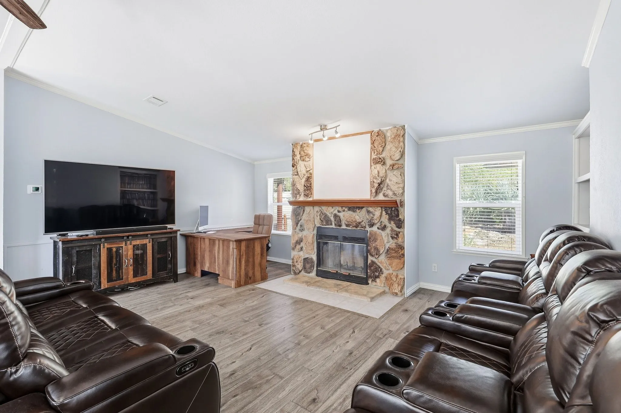 Stone Fireplace in the Living Room Creating a Warm Focal Point in this Spacious, Open Floor Plan. Waterproof, Laminate Wood Flooring.