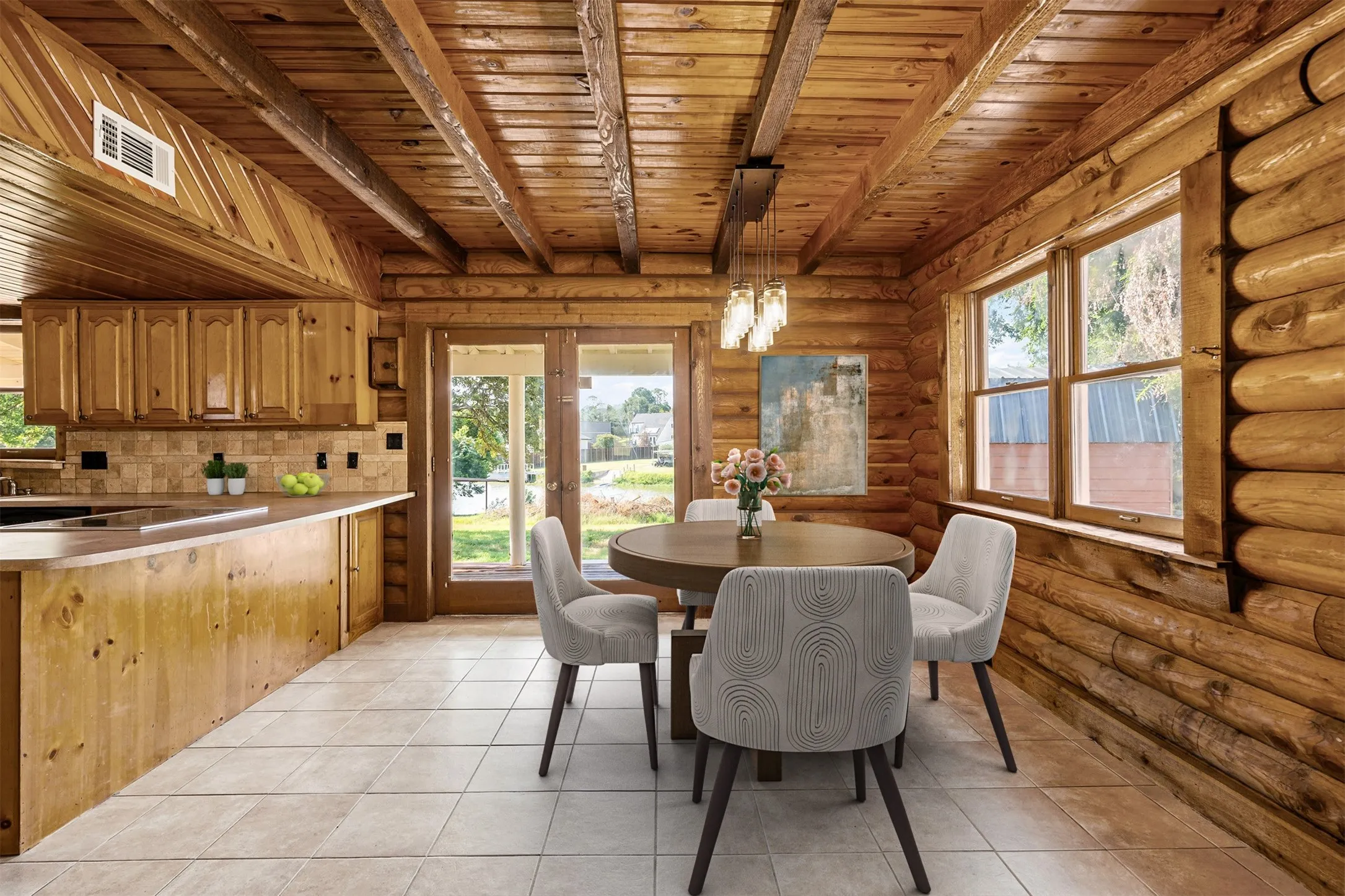 Dining room with a wooden ceiling with exposed beams, french doors, light tile patterned floors, and rustic walls