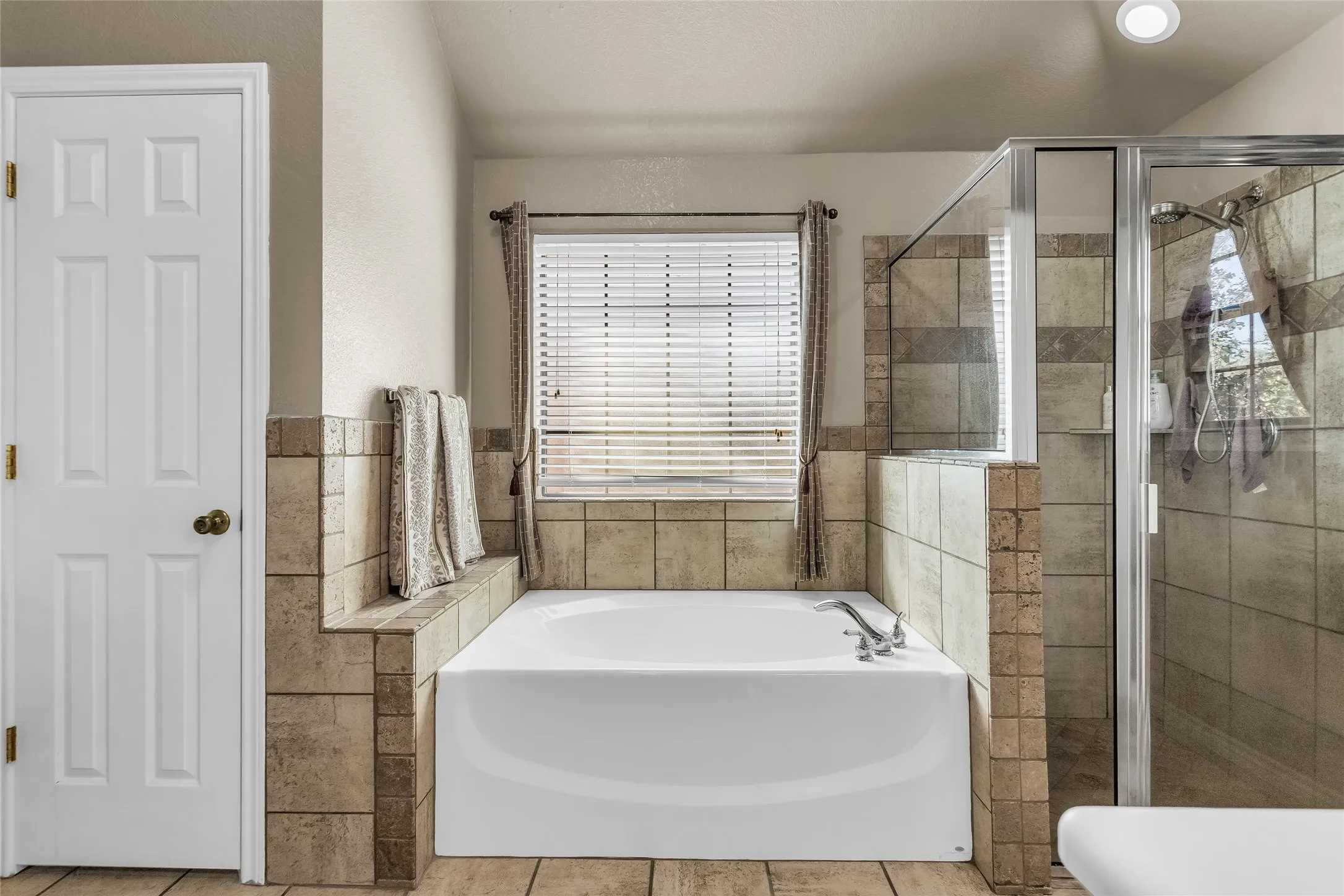 Full bathroom with a garden tub, a shower stall, and tile patterned flooring