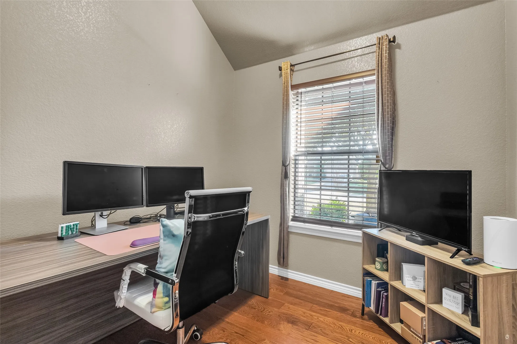 Office featuring a textured wall, dark wood finished floors, plenty of natural light, and lofted ceiling