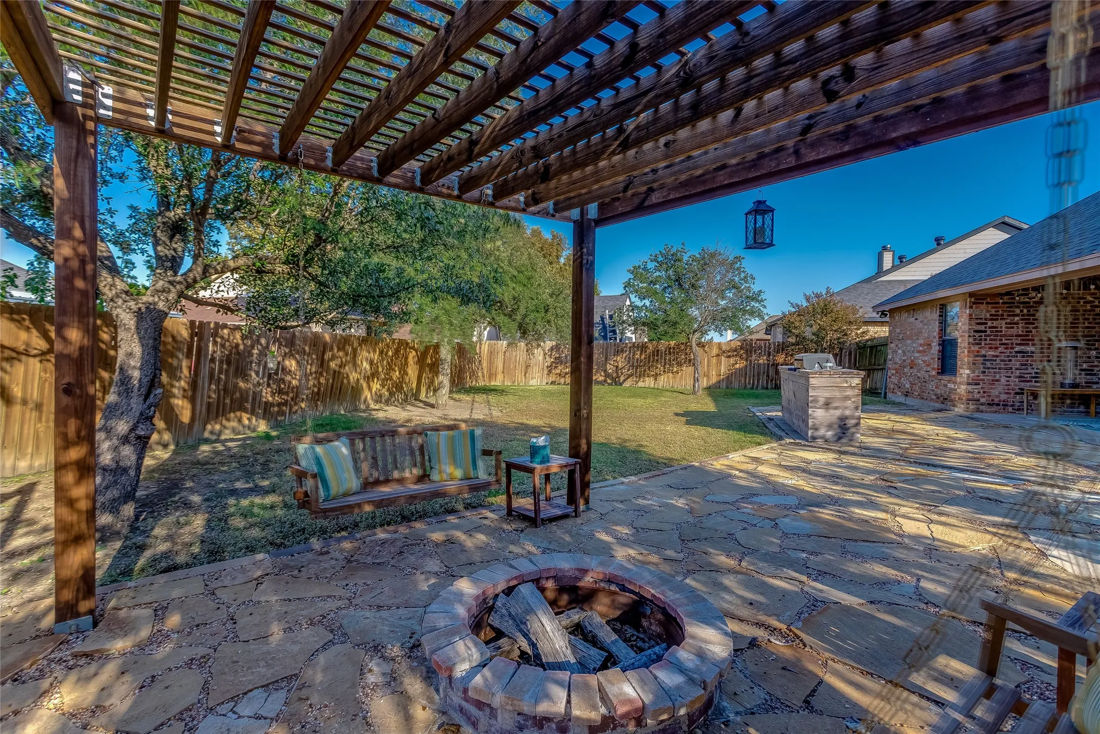 Fenced backyard with a pergola, a patio area, and an outdoor fire pit