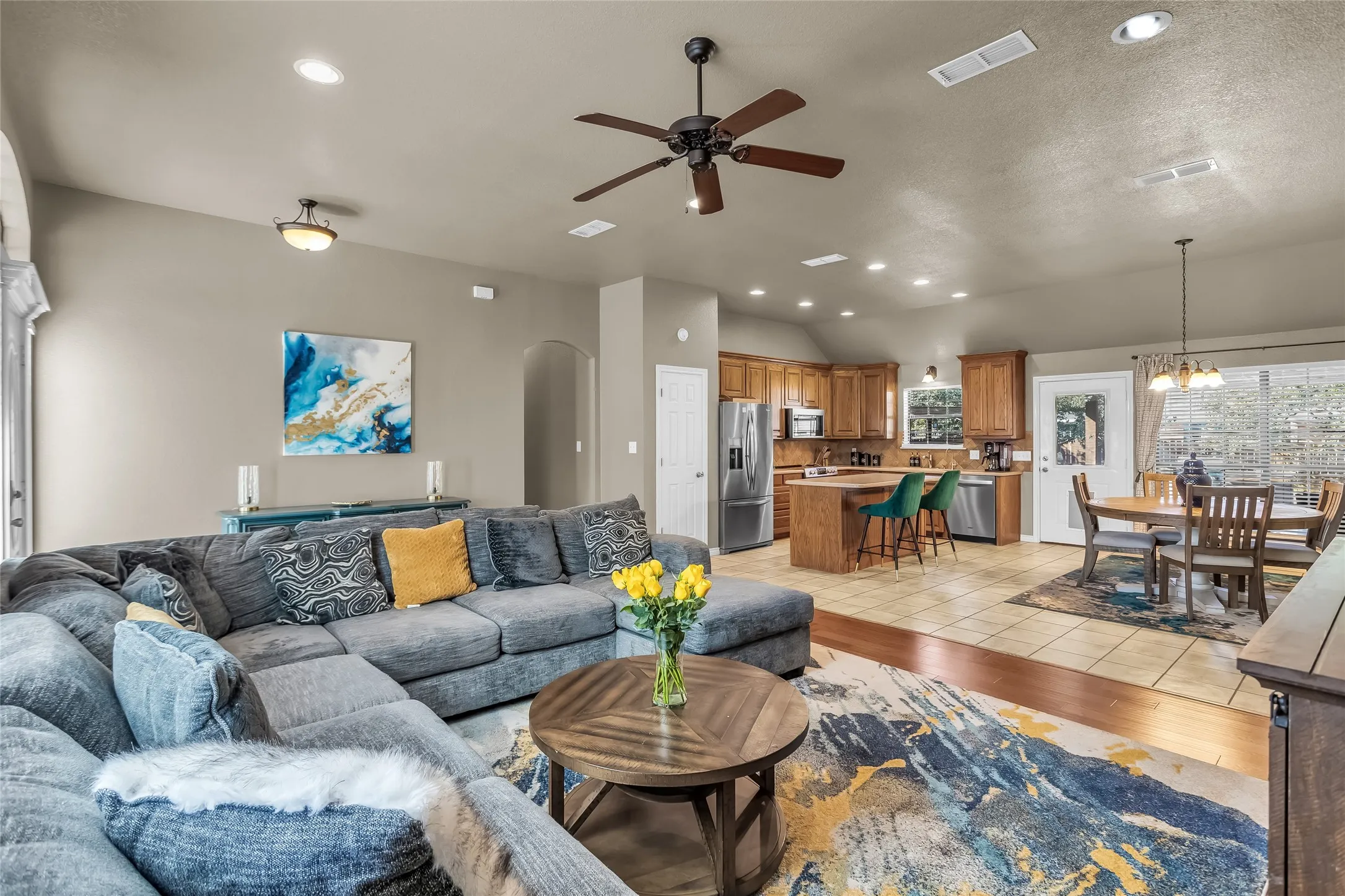 Living area featuring recessed lighting, a ceiling fan, arched walkways, light wood-style flooring, and a chandelier