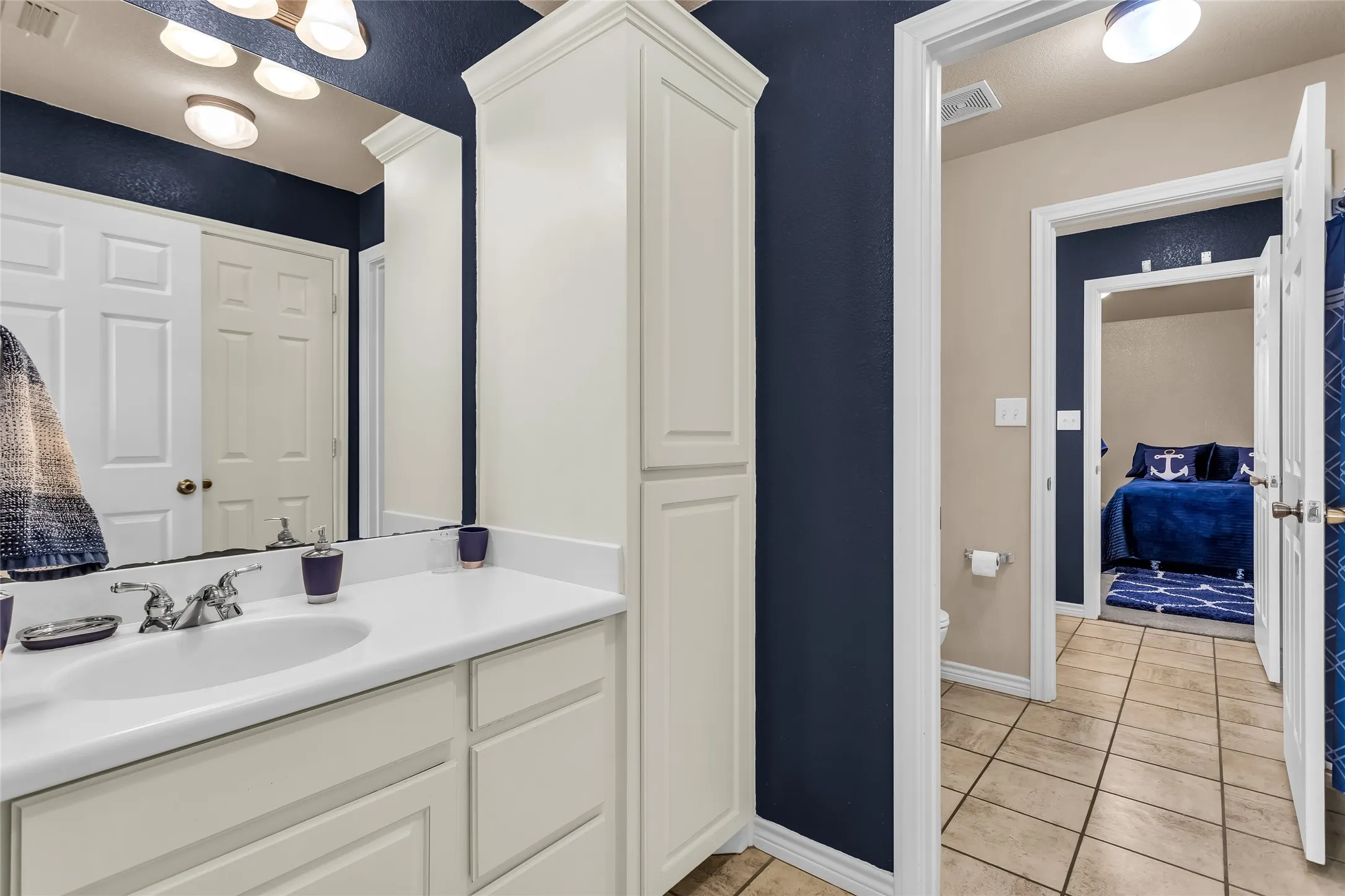 Bathroom featuring light tile patterned flooring and vanity