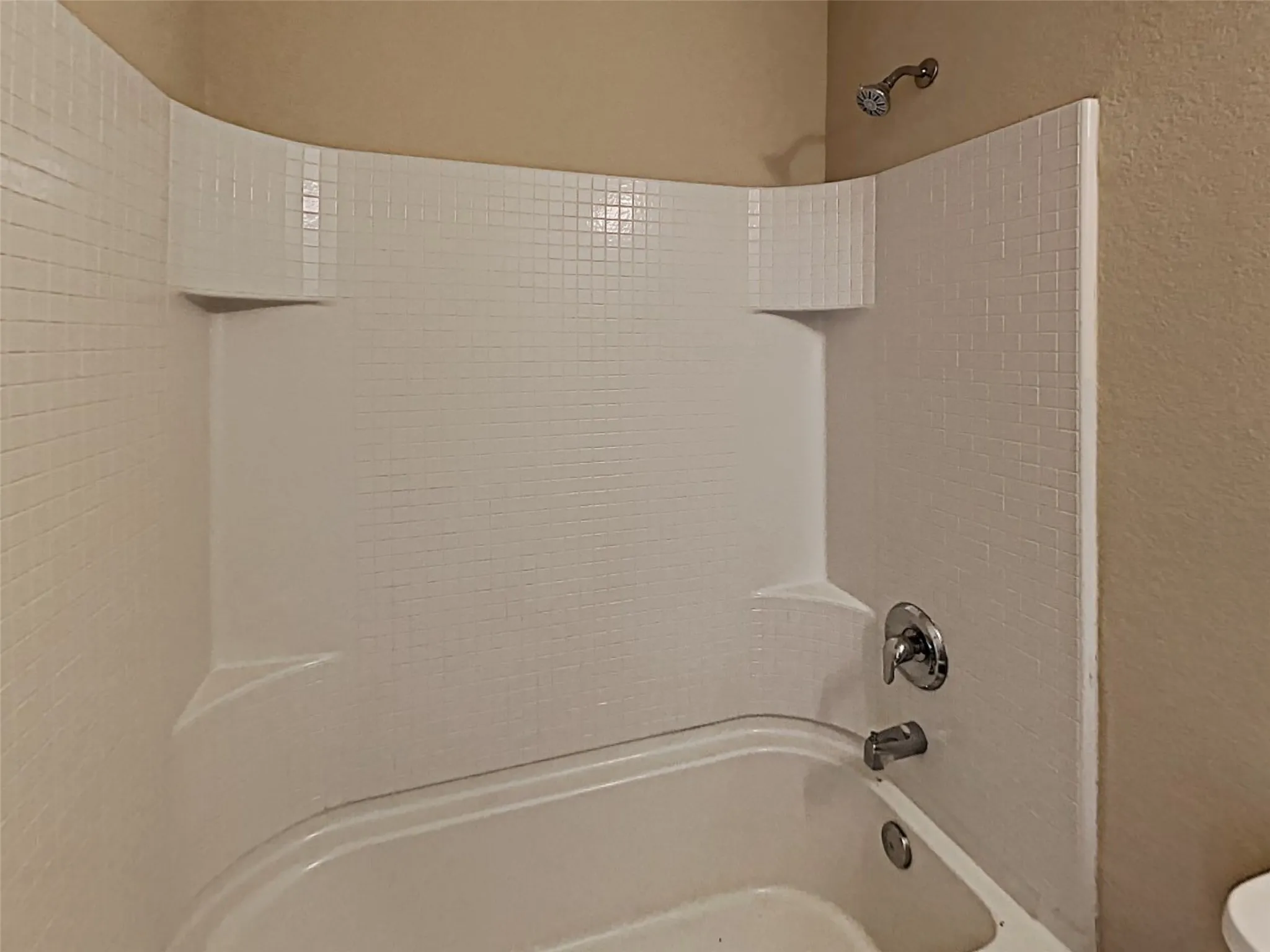 Bathroom with  shower combination and a textured wall