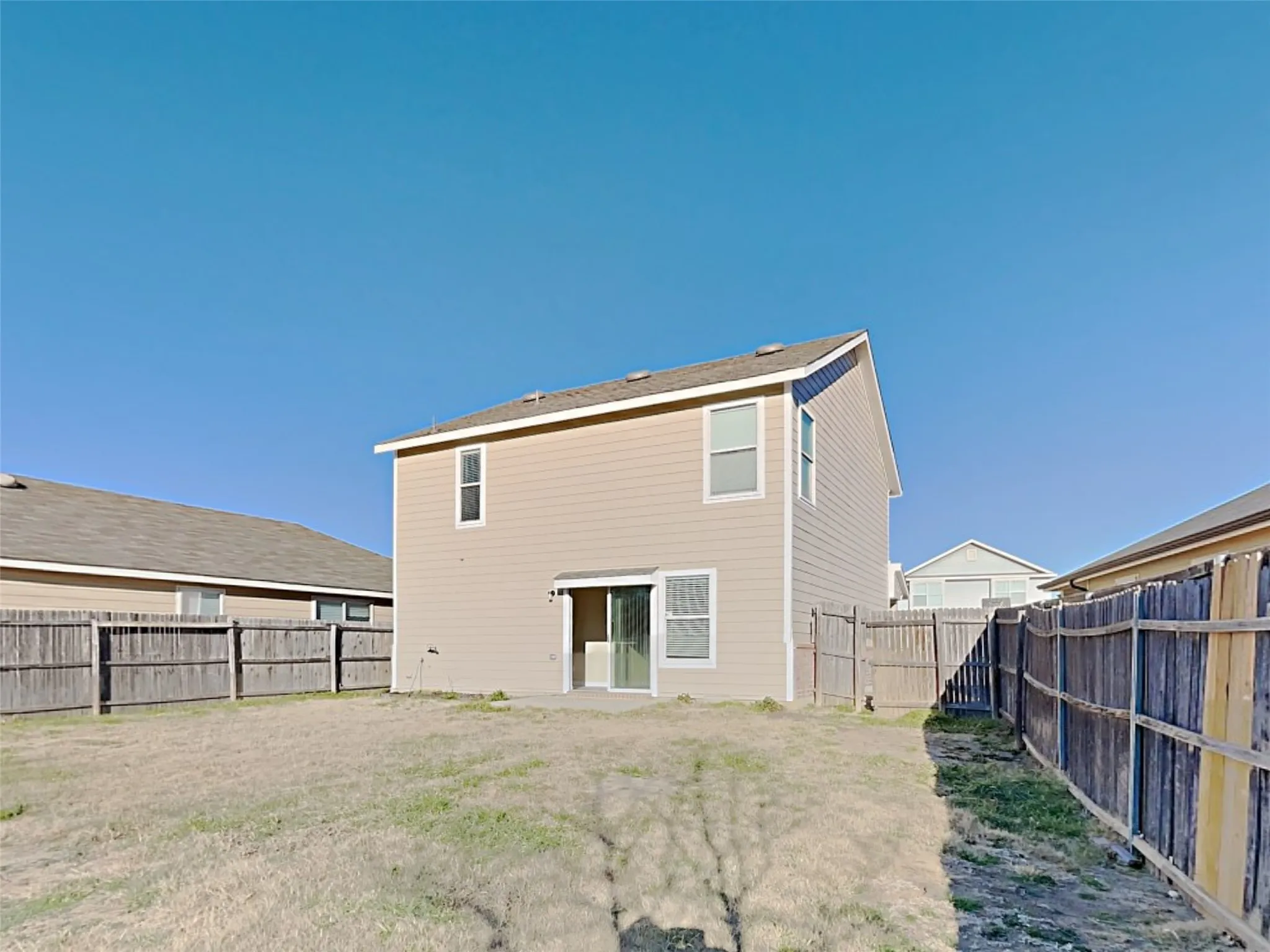 Back of property with a fenced backyard and a patio area