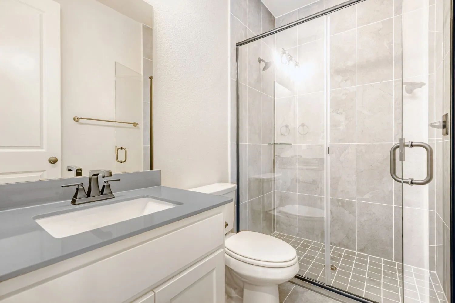 Bathroom featuring a white vanity with a light gray countertop, undermount sink, and polished chrome faucet