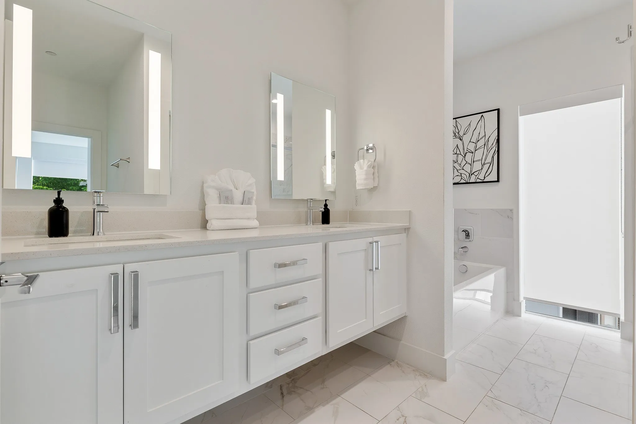 Full bathroom with double vanity, a garden tub, and light marble finish floors