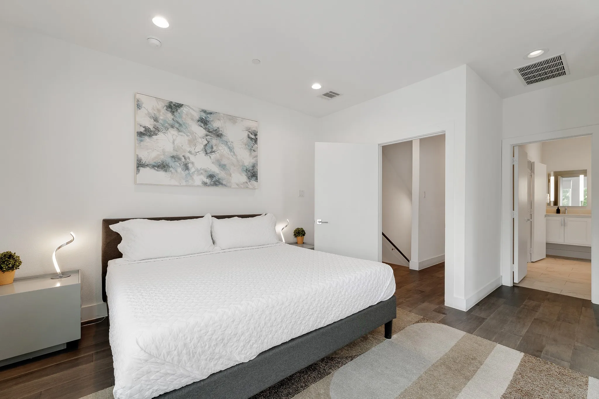 Bedroom featuring wood finished floors, recessed lighting, and connected bathroom