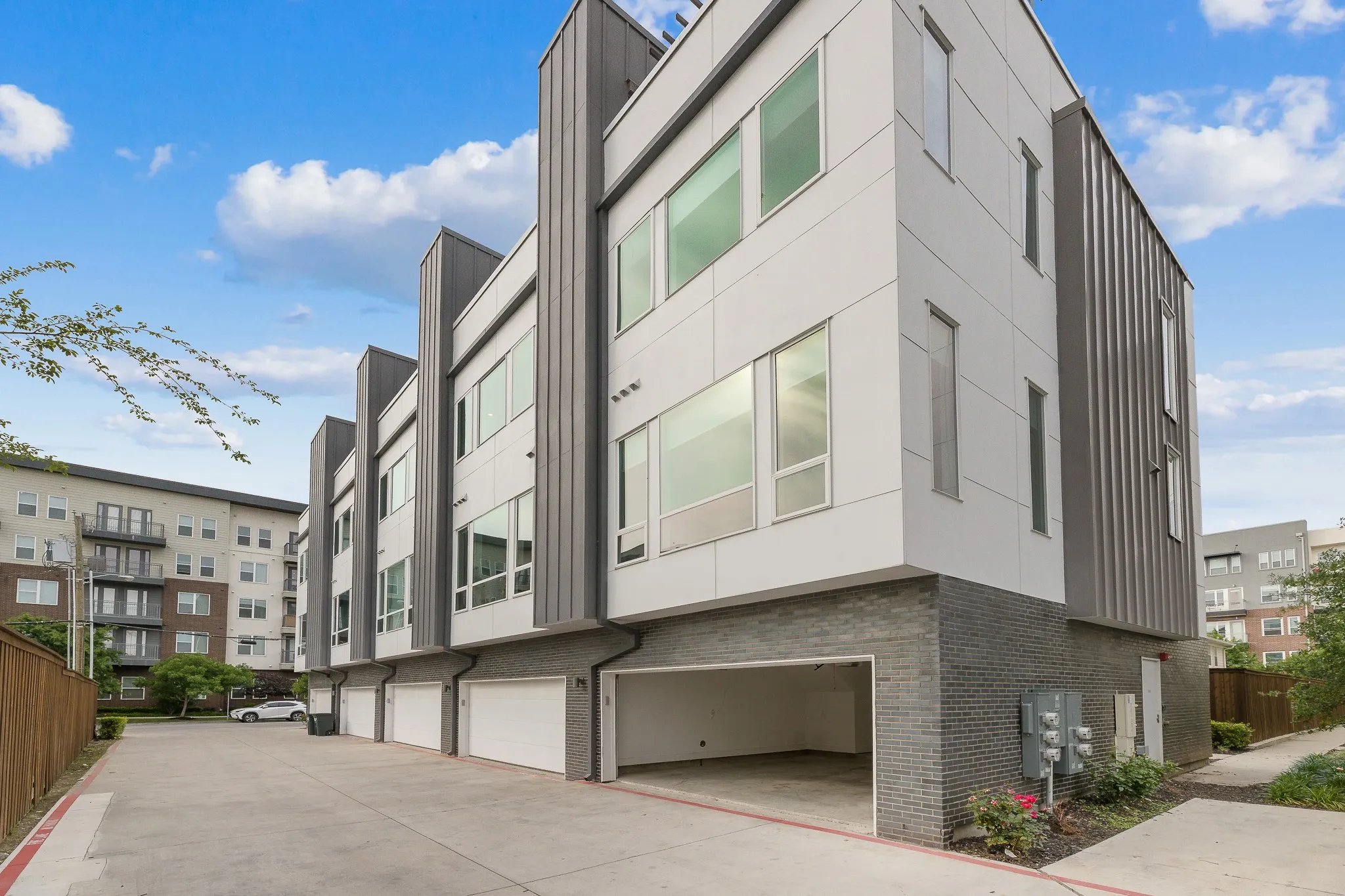 View of apartment building / complex with driveway and an attached garage
