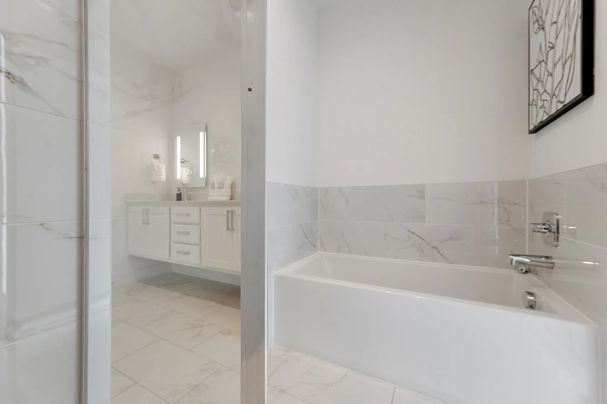 Full bath featuring light marble finish floors, vanity, and a bath