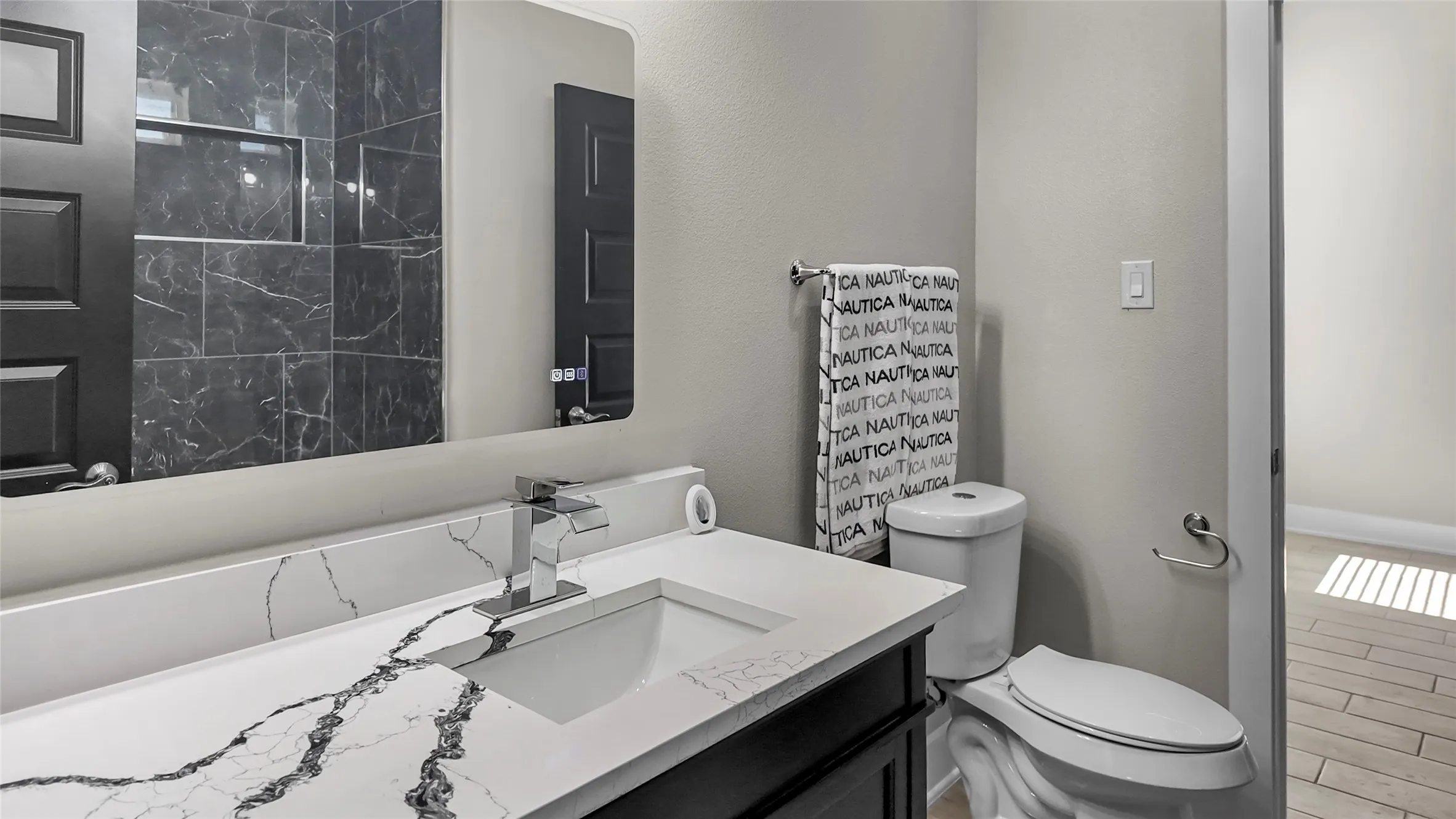 Full bath featuring vanity, a marble finish shower, wood tiled floors, and a textured wall